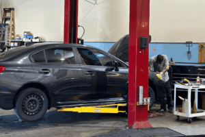 Car maintenance in Englewood, CO by Autovisions. Image of a technician working on a vehicle in a service bay, highlighting the shop’s dedication to precision repairs, safety, and keeping cars road-ready.