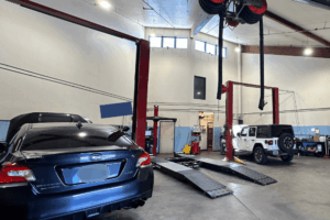 Car maintenance in Englewood, CO by Autovisions. Image showing multiple vehicles on lifts and in service bays, emphasizig full-service maintenance and repair for vehicles.
