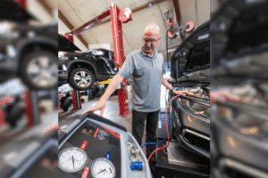 Car A/C maintenance, auto repair in Englewood, CO, at Autovisions. Image of Nathan Bryant performing an automotive A/C system recharge and diagnostic service using professional air conditioning equipment in a modern auto repair shop.