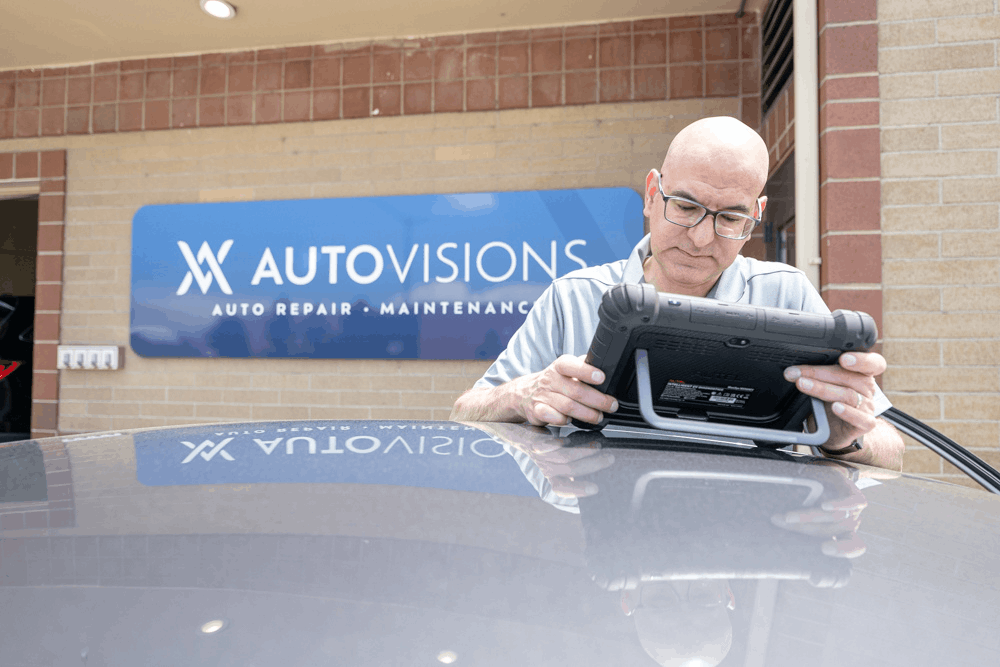 Auto repair near Denver, CO, at Autovisions. Image of Nathan Bryant using a diagnostic scan tool to identify vehicle issues and provide accurate auto repair and maintenance services.